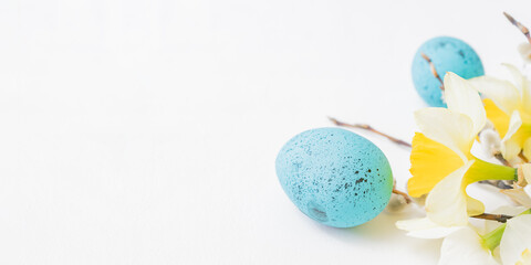 Easter composition with daffodils and eggs on white background