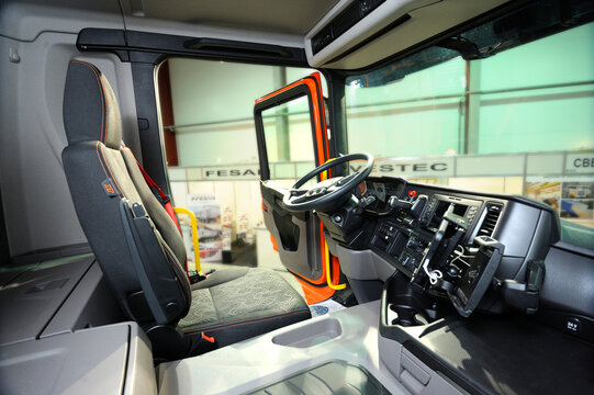 Interior of a new model of a dump truck Scania cabin: seat, wheel, dashboard