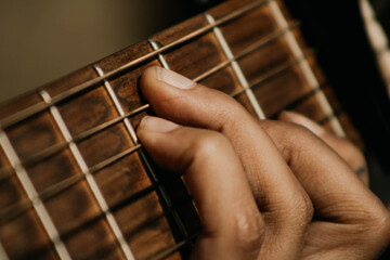 Hands of young shamanic playing guitar