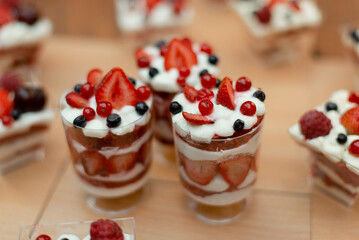 Small cakes in cups with summer berries.