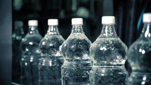 New plastic bottles on a conveyor belt at a drinking water factory.
