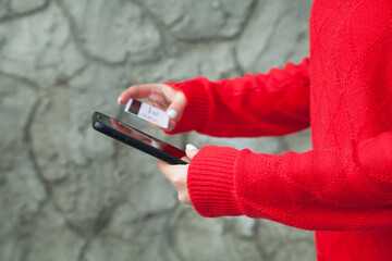 Woman holding a credit card and mobile phone.