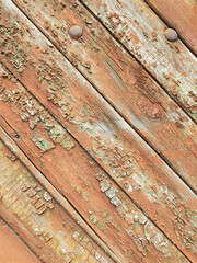 textured background of old time-worn wooden planks, set at an angle of 45 degrees, from a mixture of red, white and brown colors, siding of a wood panel of an old house, close-up, no people, patern. 