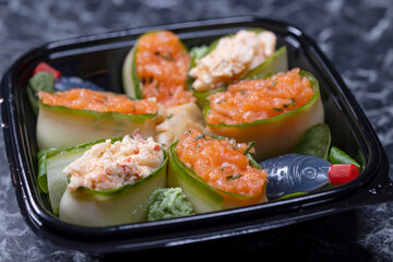 set of sushi rolls with seafood on a black stone background