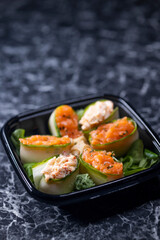 set of sushi rolls with seafood on a black stone background