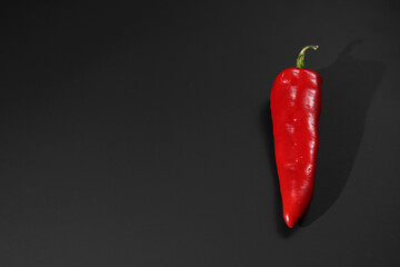 red pepper on a black background in the studio with a place for a postcard