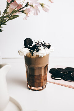 sweet yummy frappe drink with chocolate cookies on whipped cream in light kitchen