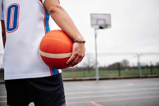 Cropped image of an unknown male standing on a basketball court. Copy space.