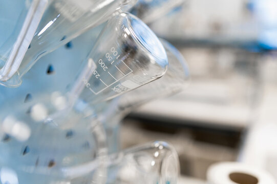 Closeup of empty glass flasks with measuring marks arranged in modern scientific laboratory