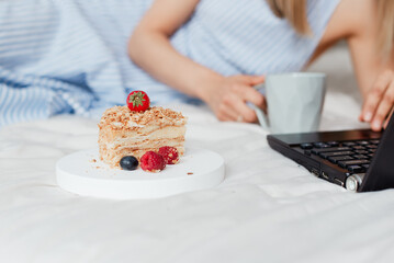 beautiful cake close-up on the bed next to a laptop