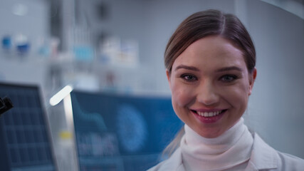 Female doctor in laboratory. Satisfied with her work. Smiling to a camera