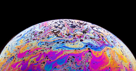 Panoramic view of closeup bubble textured backdrop representing colorful planet with wavy lines on round shaped surface on black background