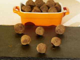 Tasty Several Truffles in a pyramid shape on black slate board