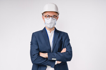 Confident caucasian engineer in medical protective mask against coronavirus with arms crossed isolated over white background