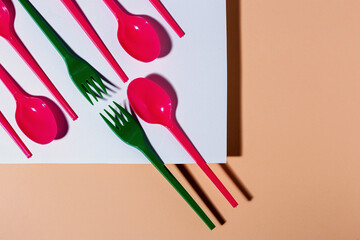 Overhead view of colorful eco friendly cutlery on pastel background