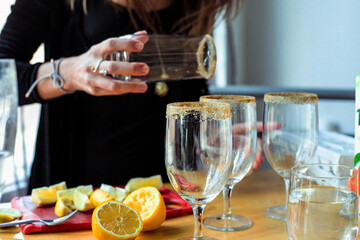 Woman applying sugar rim on glasses at table
