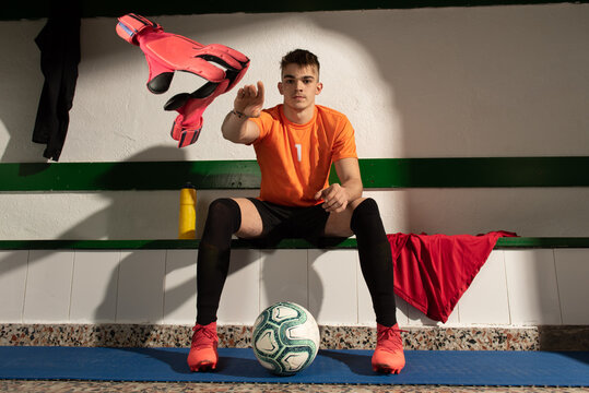A football player in dressing room with sports uniform