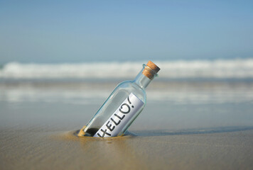 Hello, bottle on beach with greeting © joserpizarro