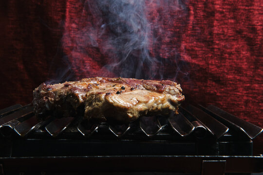 Pieces Of Raw Beef Meat Preparing On Hot Metal Grill In Kitchen Of Restaurant