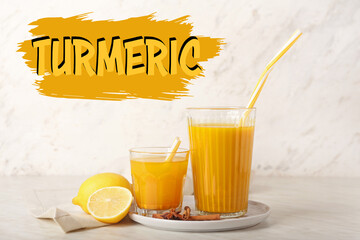 Glasses of healthy turmeric drink on white background