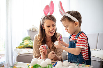 Mother and her son preparing for Easter, painting Easter eggs. Mother And Son Enjoying Creative Easter Morning, Coloring Eggs. Coloring Eggs For Easter