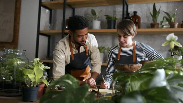 Shop assistants working in indoor potted plant store, small business concept.