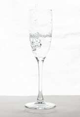 Filling up the champagne glass water  isolated on a white background