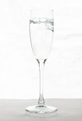 Filling up the champagne glass water  isolated on a white background