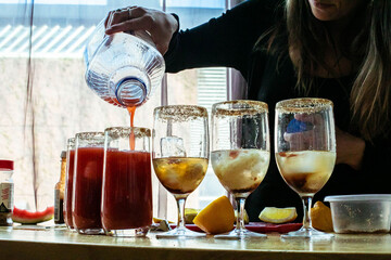 Woman pouring drink in glass on table