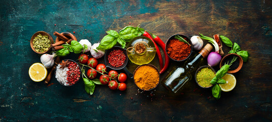 Fragrant spices, herbs and basil on a dark wooden background. Top view. Free space for text.