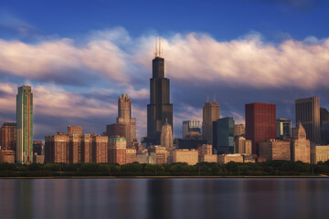 Cityscape of Chicago with contemporary buildings and towers reflecting in calm lake water on a sunny day