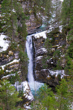 Wasserfall mit Felsen und Schnee in einen See m&uuml;ndend