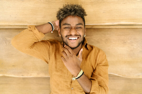 Handsome young bearded hipster black guy with curly hair and looking at camera