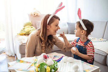 Mother and her son preparing for Easter, painting Easter eggs. Mother And Son Enjoying Creative...