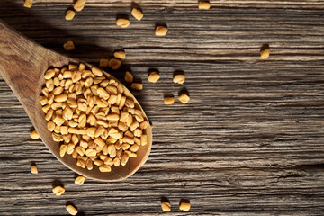 Fenugreek seeds on a spoon on a table