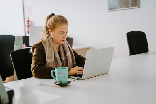 Blonde business woman working in front of computer in an office