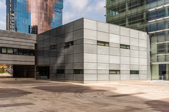 Modern skyscraper and rectangular shaped construction on urban pavement under cloudy sky in daylight
