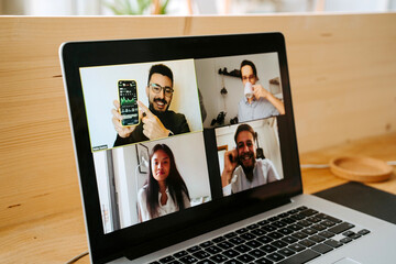 Diverse coworkers talking on video conference online via netbook while discussing project during coronavirus pandemic