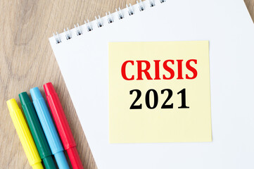 yellow paper on notebook with the text Crisis 2021. Business concept