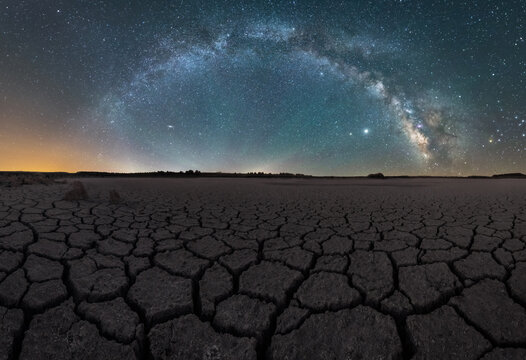 Drought Cracked Lifeless Ground Arid Terrain With Starry Sky At Night