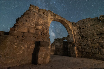 Milky Way galaxy through arch entrance of old ruined castle at night