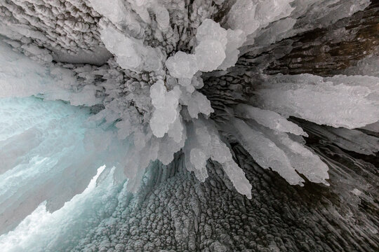 From above of frozen Lake Baikal surface with chaotic pattern and cracks as abstract background