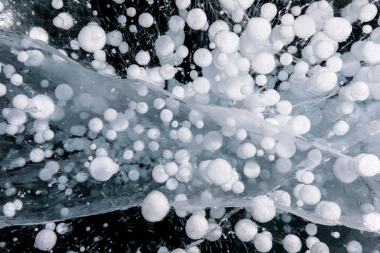 Top view of amazing frozen methane bubbles under water of icy Lake Baikal in winter as abstract background