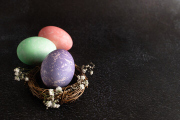 Pastel stone colored easter eggs on a dark background. Dark theme.