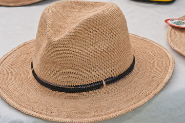 top, front view, close distance of man and woman"s straw hats on display and for sale at a tropical farmers market