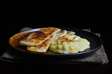Corn porridge with cheese and sliced ​​flatbread.  Elarji is a popular dish from Georgian, made from coarse cornmeal, cornflour and Sulguni cheese.