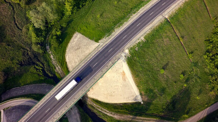Aerial Top View of White Truck with Cargo Semi Trailer Moving on Road in Direction f Loading Warehouse Area.