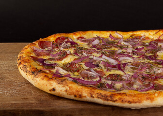 Pizza with cheese, pepperoni or calabresa and red onion on wooden board 