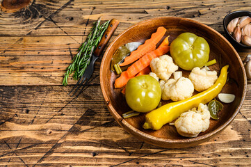 Salted and pickles vegetables preserve in a wooden plate. wooden background. Top view. Copy space