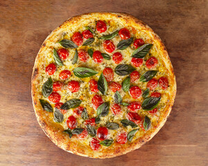 Top view of isolated pizza with cherry tomatoes, basil and mozzarella cheese, or Margherita on wooden board 